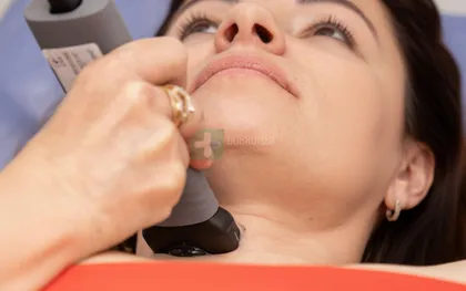 Врач-УЗИст проводит исследование щитовидной железы пациенту