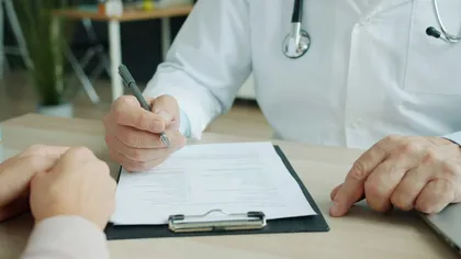 Лікар-уролог заповнює картку пацієнта на консультації